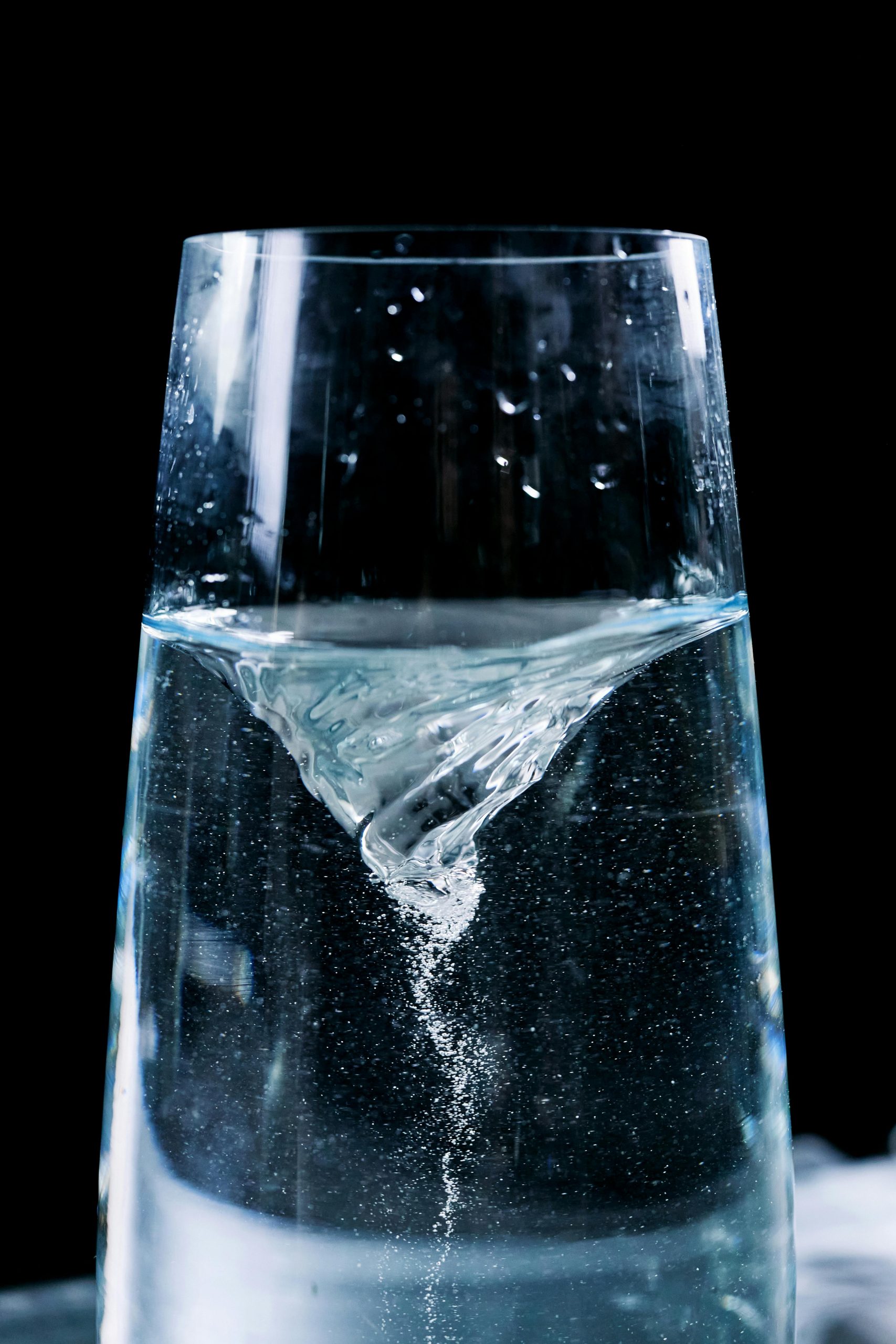 pexels photo 9667974 9667974 Close-up of a mesmerizing water vortex in a glass with droplets against a dark background.